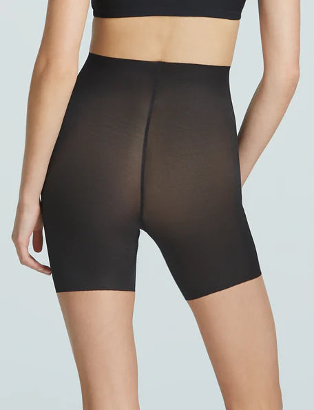 Black shapewear shorts worn by a model on a light gray background
