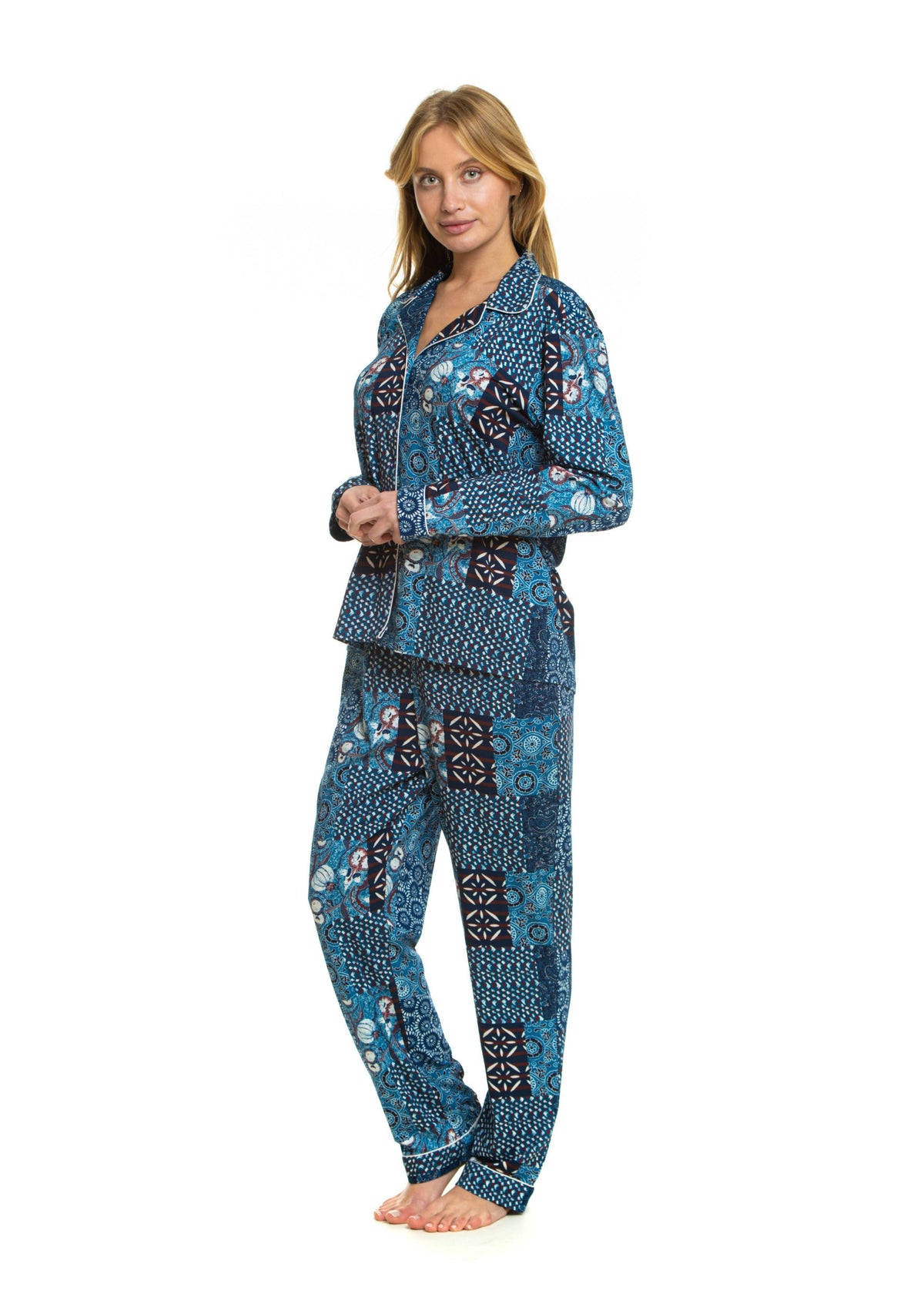 A woman modeling a matching two-piece pajama set with a blue, black, and white patchwork-style geometric pattern, standing against a plain white background.