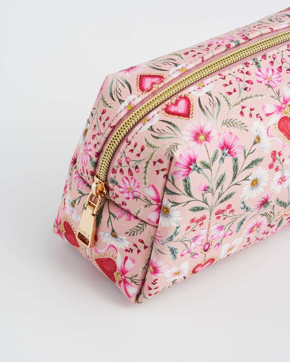 Floral and heart-patterned makeup bag with a gold zipper on a light gray background