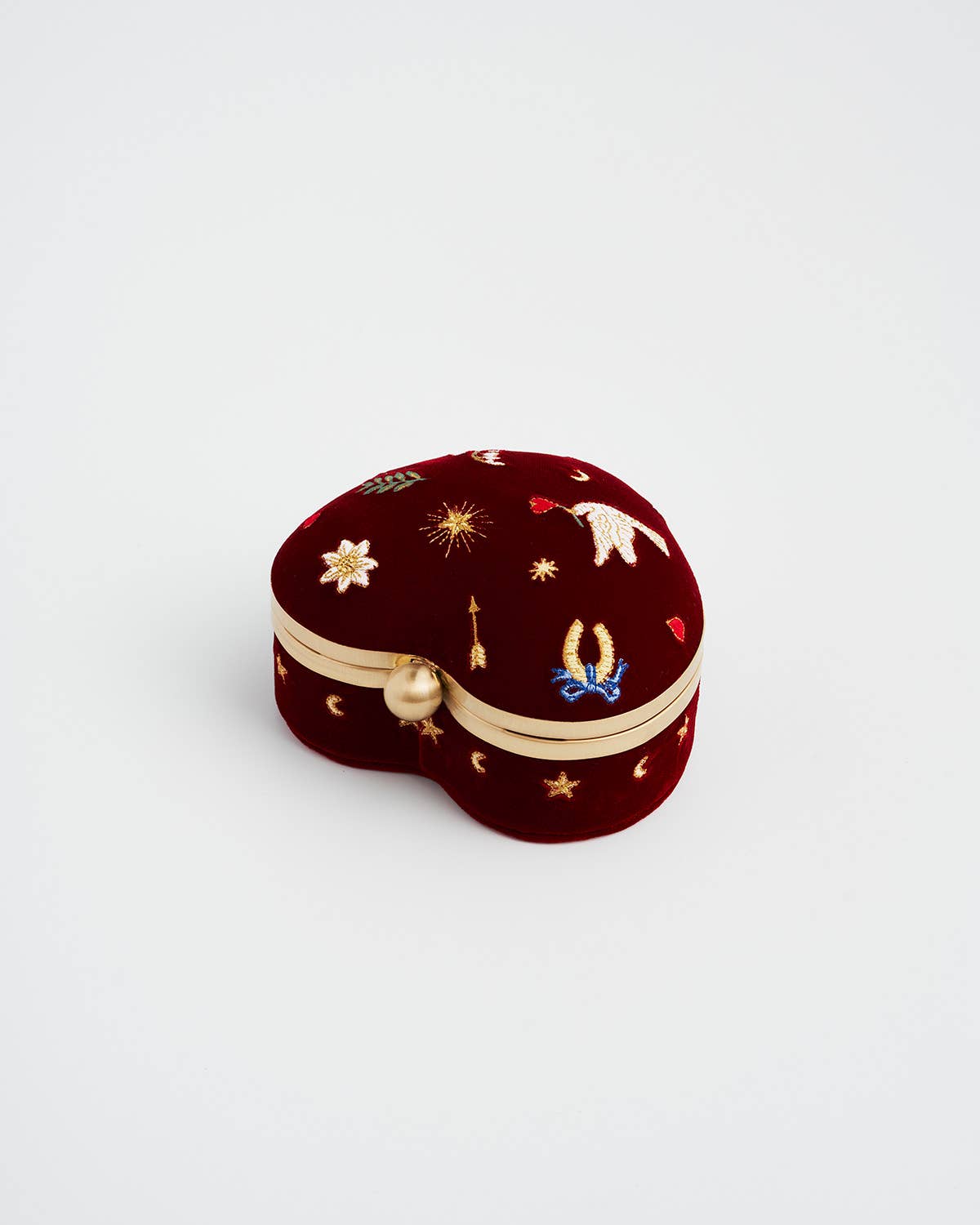Side View Heart-shaped jewelry box with embroidered designs on a light grey background