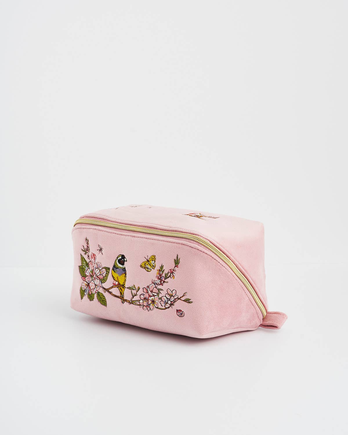 Pink cosmetic bag with floral and bird design on a light pink background