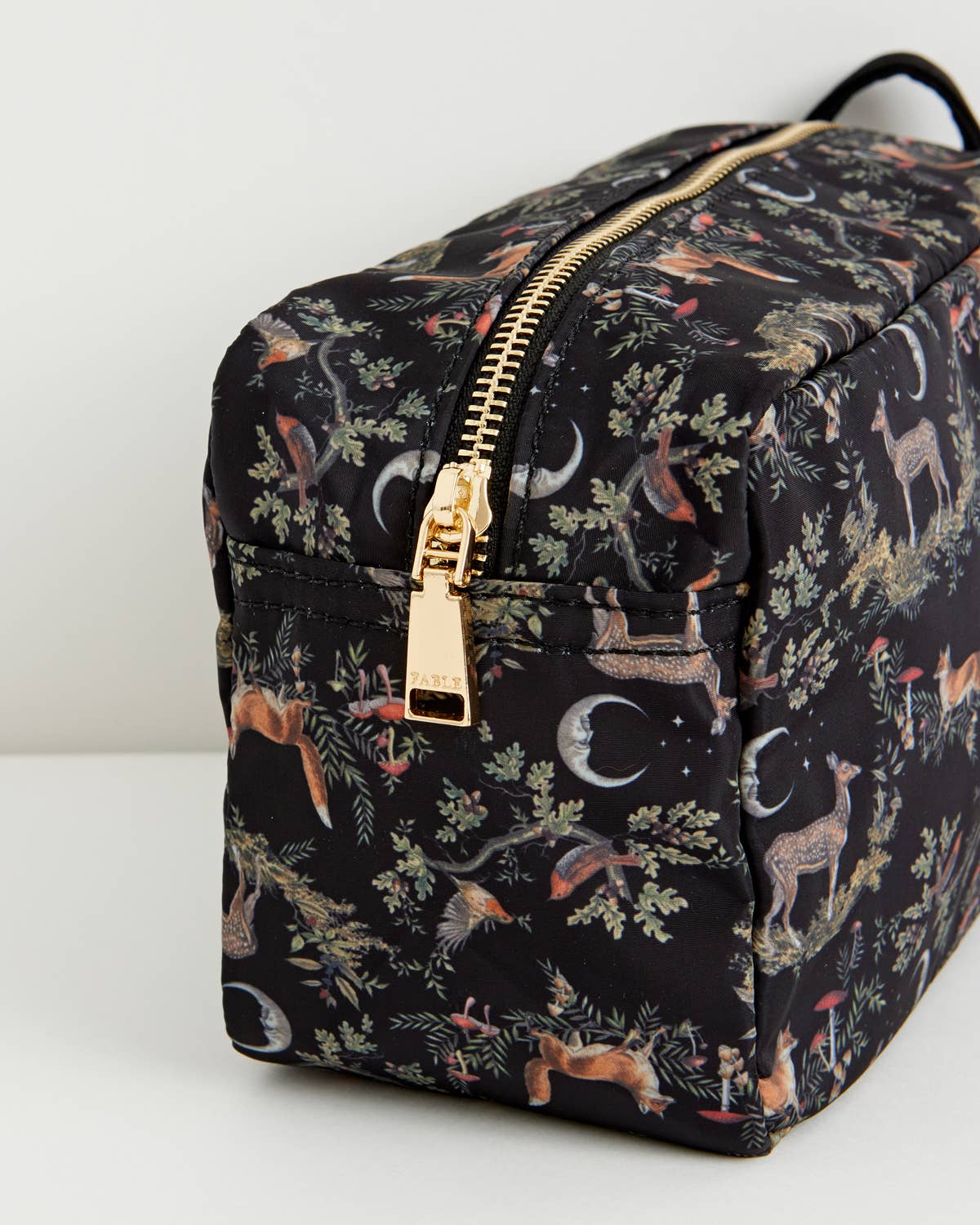 Floral-patterned toiletry bag with gold zipper on a white background