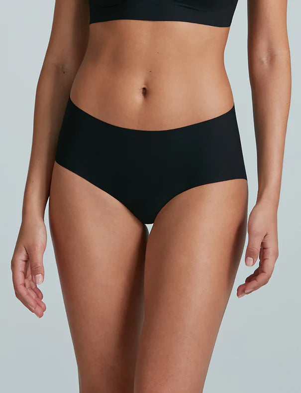 Person wearing black high-waisted bikini bottoms on a plain background