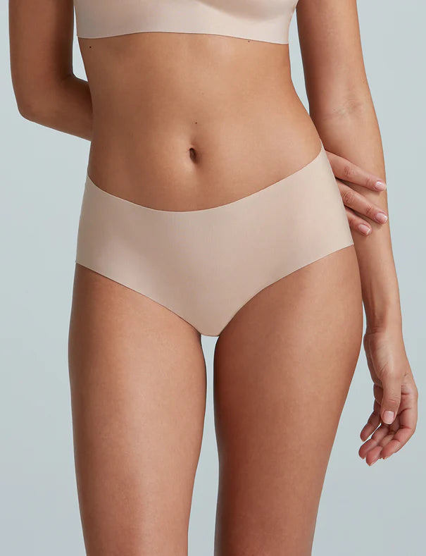 Beige underwear on a person against a light gray background