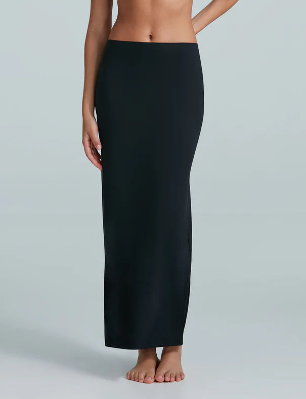 Person wearing a black skirt on a plain background