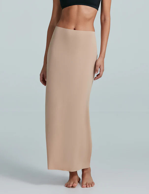 Beige slip skirt worn by a person on a plain background