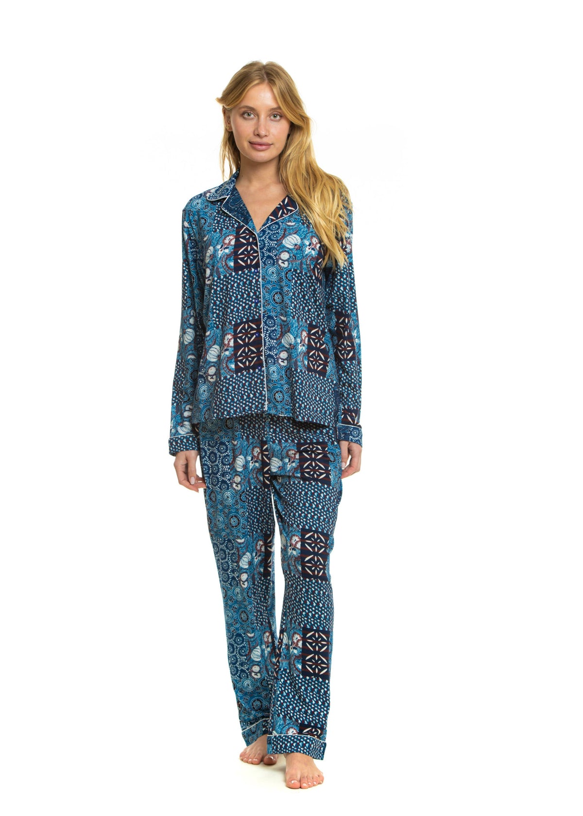A woman modeling a two-piece pajama set with a blue, black, and white geometric pattern, standing against a solid white background.