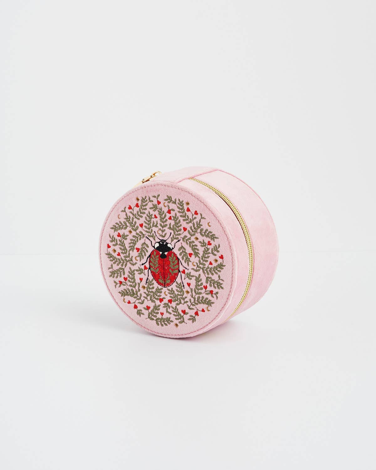 Round pink pouch with a ladybug design on a white background