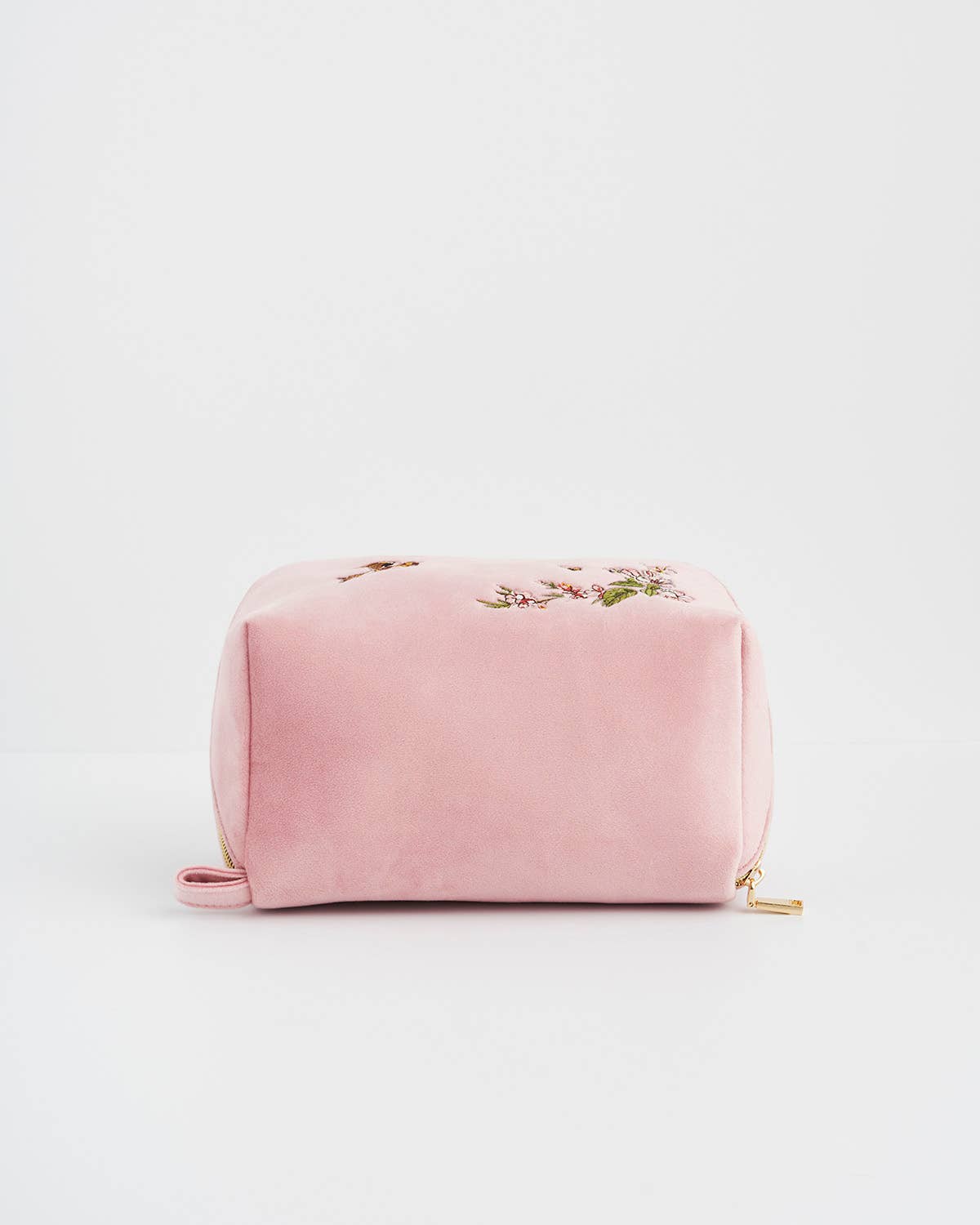 Pink velvet pouch with floral embroidery on a white background